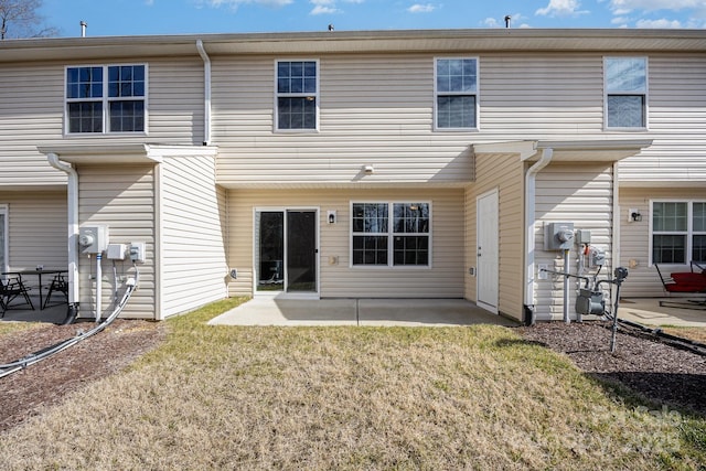 back of property featuring a patio and a lawn