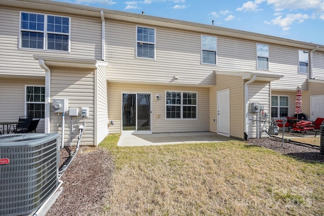 rear view of property featuring a yard, central AC, and a patio