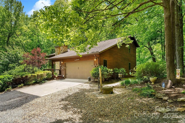 33 Cammies Way, Old Fort, NC 28762 - view of side of property featuring driveway, an attached garage, a shingled roof, and a chimney