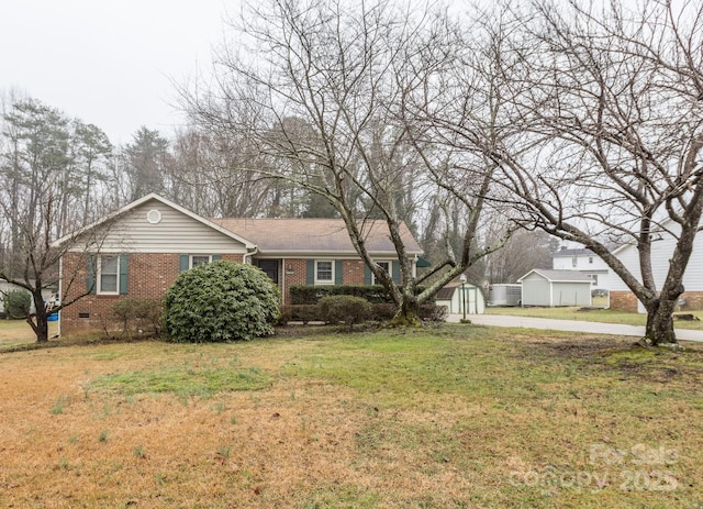 ranch-style home with a storage shed and a front yard