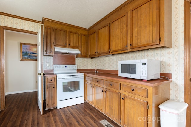 kitchen with white appliances and dark hardwood / wood-style flooring