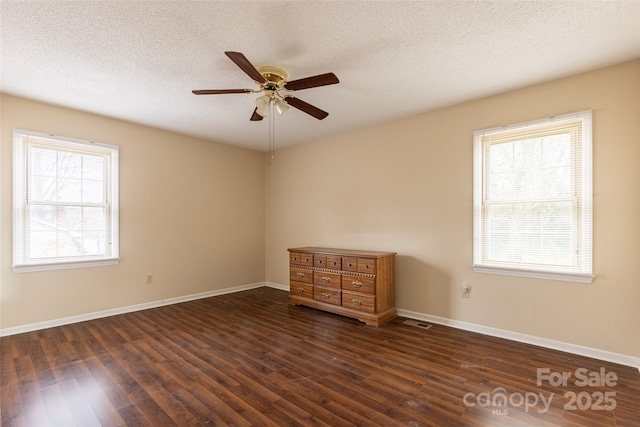 unfurnished room featuring ceiling fan, dark hardwood / wood-style floors, and a textured ceiling