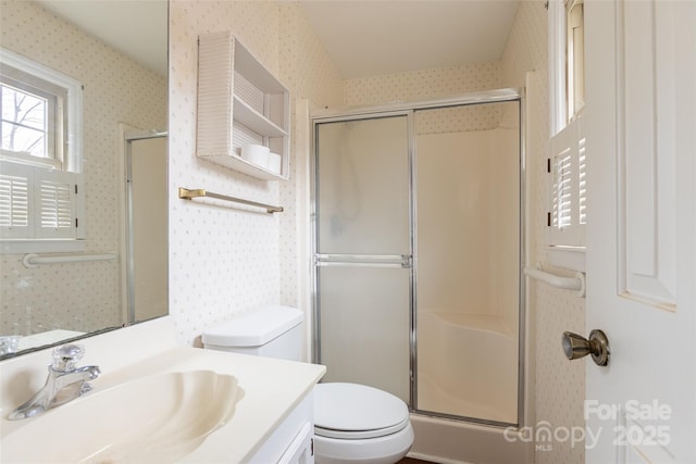 bathroom featuring vanity, toilet, and walk in shower