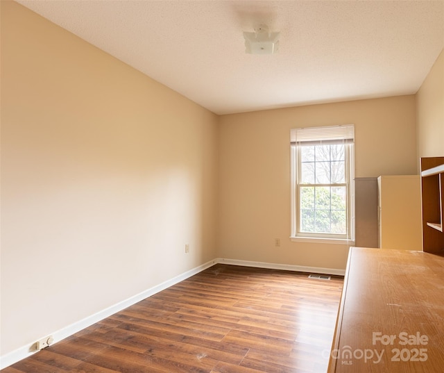 unfurnished room with hardwood / wood-style flooring