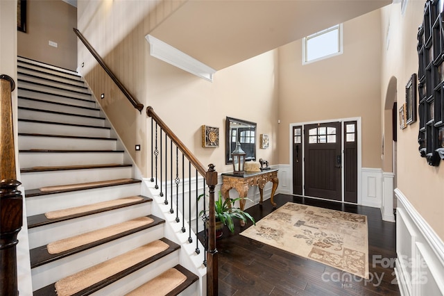 foyer entrance featuring a high ceiling and dark wood-type flooring