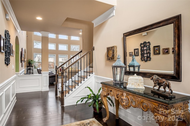 interior space featuring crown molding, wood-type flooring, and ornate columns