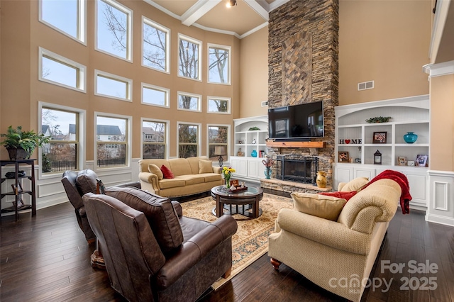 living room with ornamental molding, plenty of natural light, dark hardwood / wood-style floors, and a fireplace