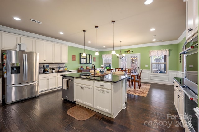 kitchen featuring stainless steel appliances, white cabinetry, sink, and a center island with sink