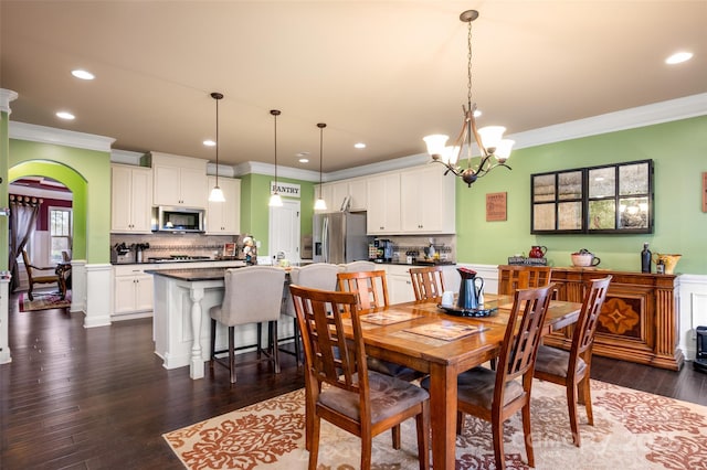 dining area featuring an inviting chandelier, ornamental molding, and dark hardwood / wood-style floors