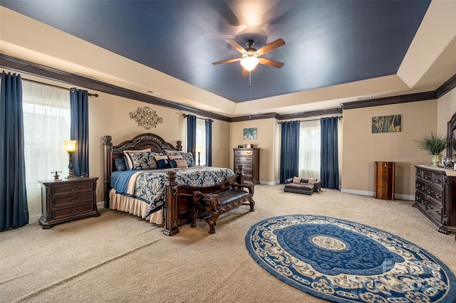 bedroom with crown molding, ceiling fan, a tray ceiling, and light carpet