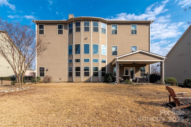 rear view of property with a lawn and ceiling fan