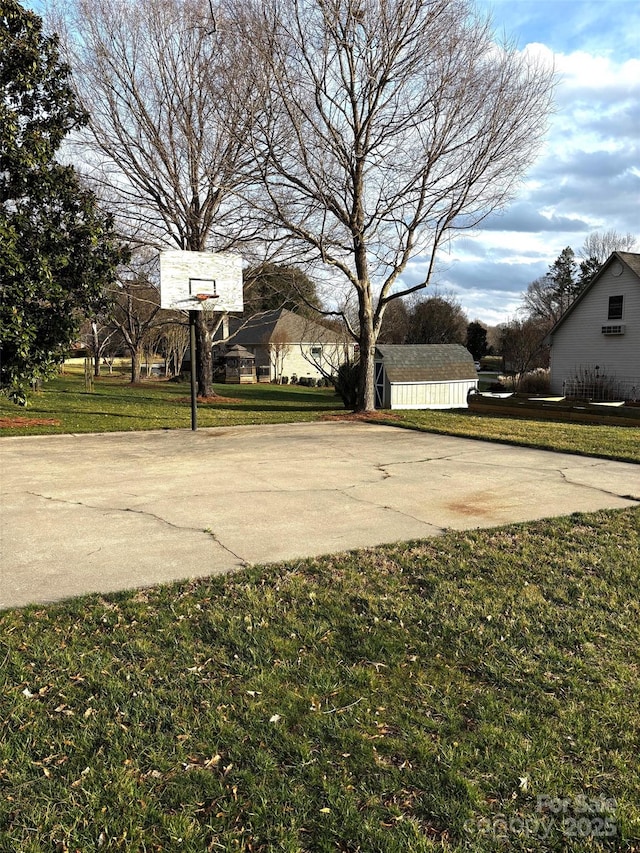 view of basketball court featuring basketball court and a lawn