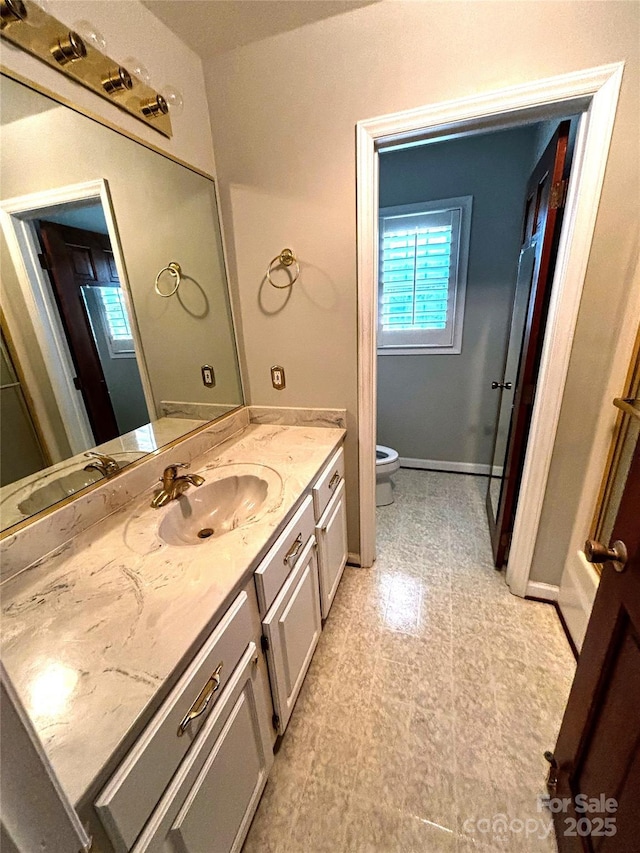 bathroom with tile patterned floors, vanity, toilet, and baseboards