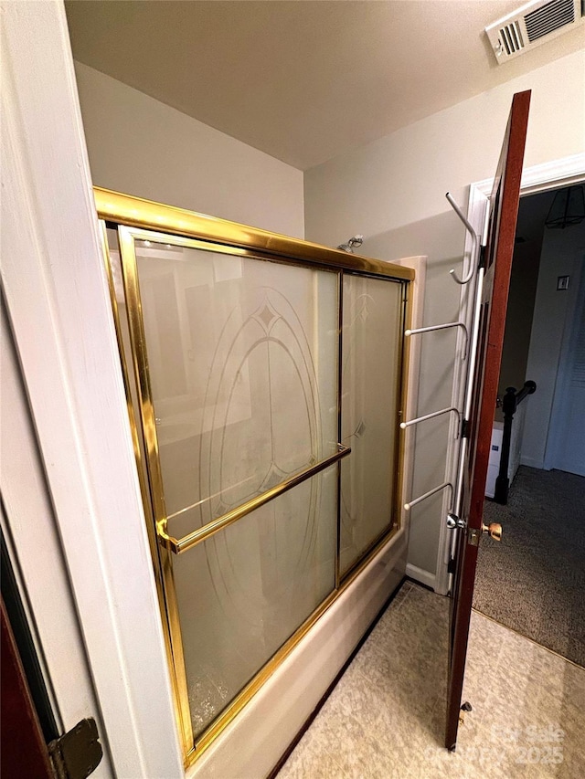 bathroom with visible vents and bath / shower combo with glass door