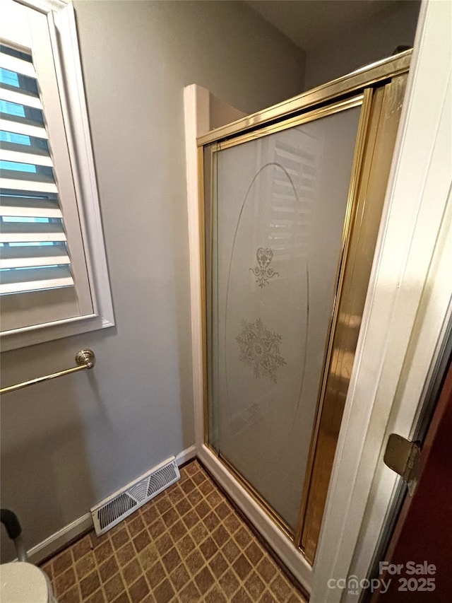 full bathroom featuring a shower stall, visible vents, and baseboards