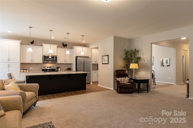 living area with light carpet, baseboards, and recessed lighting