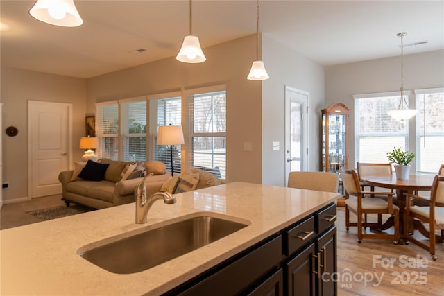 kitchen with a healthy amount of sunlight, visible vents, a sink, and decorative light fixtures