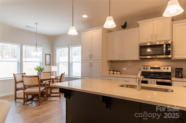 kitchen with appliances with stainless steel finishes, white cabinets, and decorative backsplash