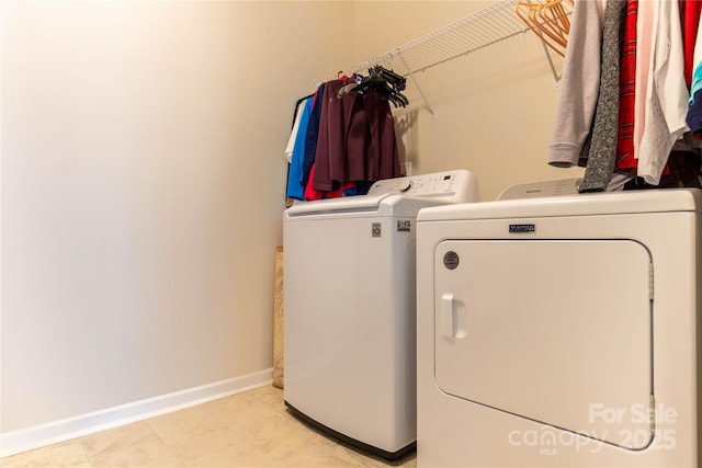 laundry room with laundry area, baseboards, and separate washer and dryer