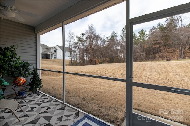 unfurnished sunroom with ceiling fan