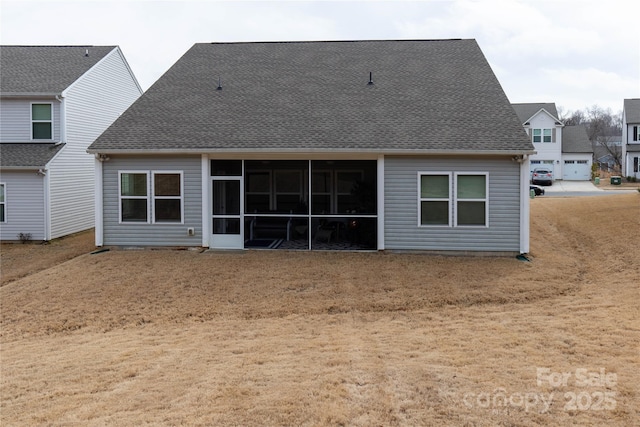 rear view of property with a sunroom and roof with shingles