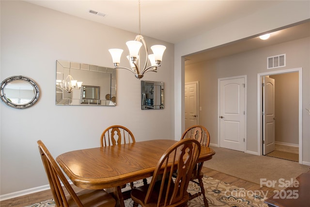 dining room with baseboards, visible vents, and an inviting chandelier