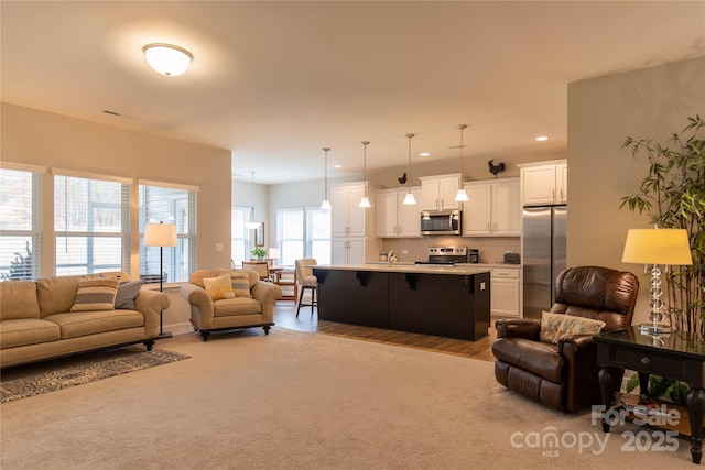 carpeted living room featuring a sink and recessed lighting