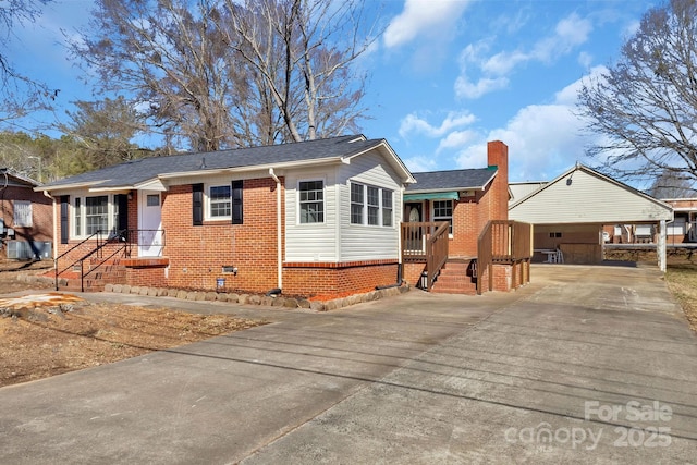 view of front of property with brick siding, a chimney, concrete driveway, covered porch, and crawl space