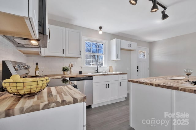 kitchen featuring tasteful backsplash, butcher block counters, white cabinets, and stainless steel appliances