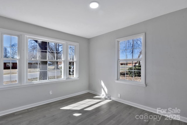 spare room with dark wood-style floors and baseboards