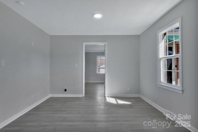 empty room featuring dark wood finished floors and baseboards