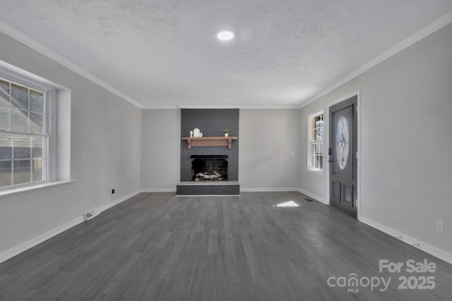 unfurnished living room featuring dark wood-style flooring, crown molding, a brick fireplace, a textured ceiling, and baseboards