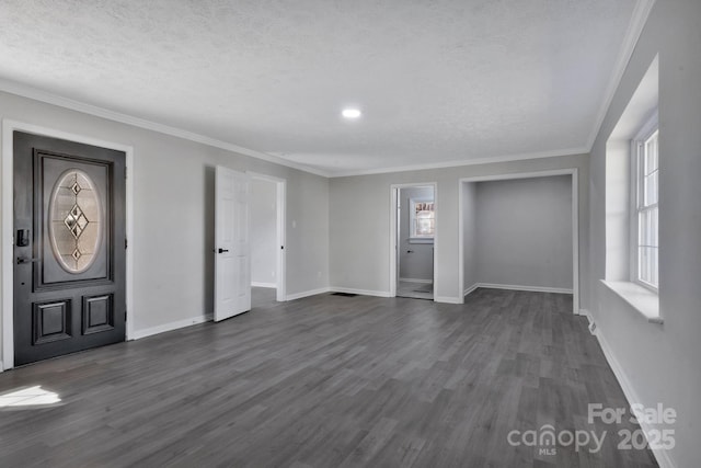 foyer entrance with baseboards, a textured ceiling, ornamental molding, and dark wood-style flooring