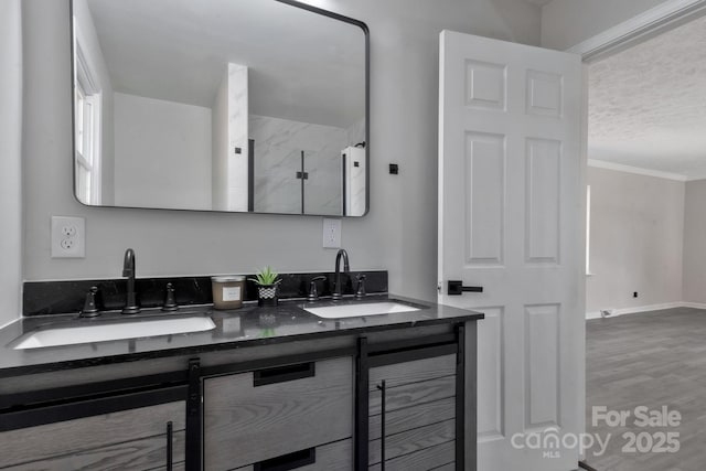 full bath featuring ornamental molding, wood finished floors, a sink, and double vanity