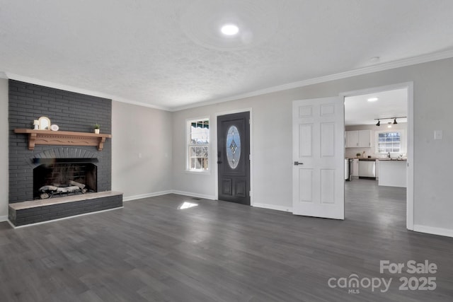 foyer entrance featuring dark wood-type flooring, a brick fireplace, ornamental molding, and a textured ceiling