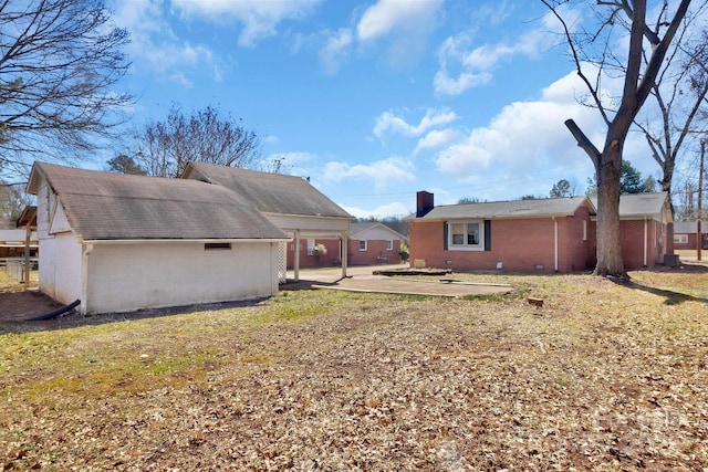 rear view of property with brick siding and a chimney