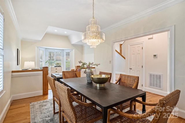 dining room featuring ornamental molding, a chandelier, and light wood-type flooring