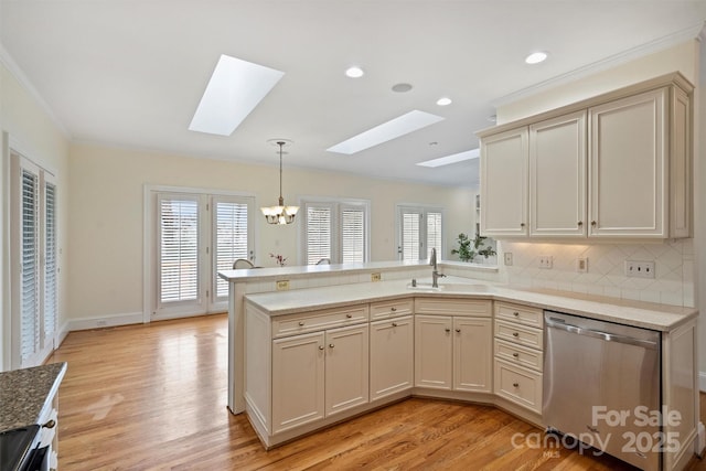 kitchen with pendant lighting, dishwasher, kitchen peninsula, and cream cabinetry