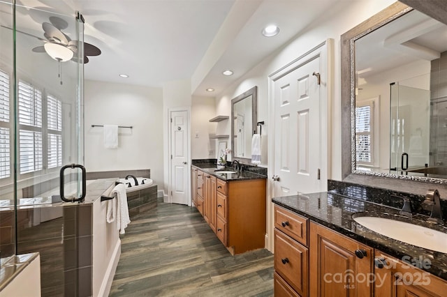 bathroom with ceiling fan, wood-type flooring, independent shower and bath, and vanity