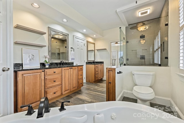 bathroom featuring a shower with door, vanity, hardwood / wood-style floors, and toilet