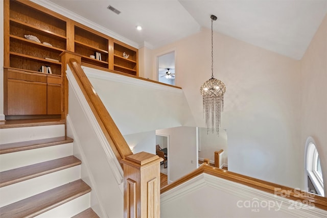 staircase with lofted ceiling and a notable chandelier