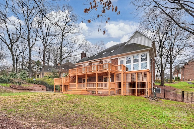 rear view of house with a lawn and a deck