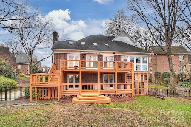 rear view of property with a deck and a lawn