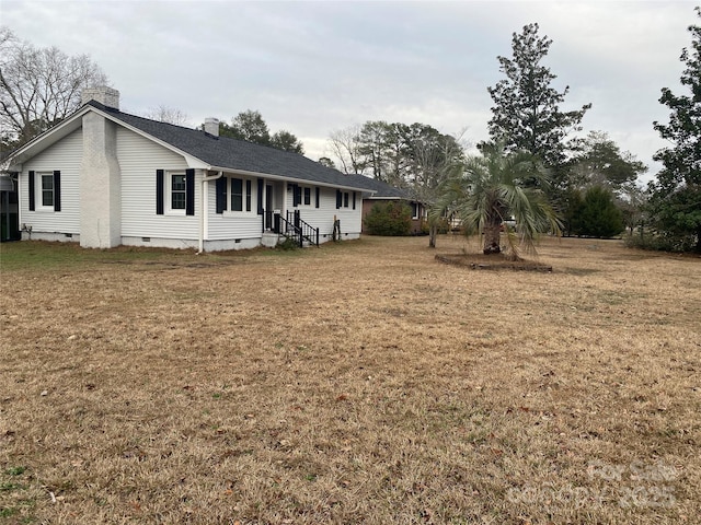 exterior space featuring a front lawn, crawl space, and a chimney