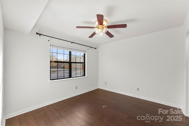 empty room with ceiling fan and dark hardwood / wood-style flooring