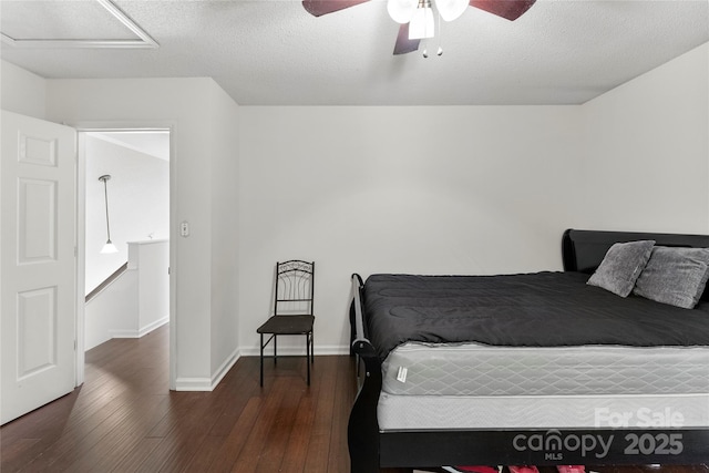 bedroom featuring a textured ceiling, dark wood-type flooring, and ceiling fan