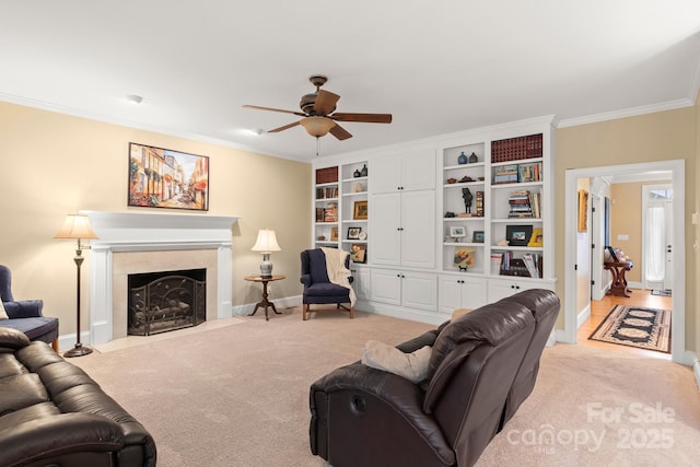 carpeted living room with crown molding, ceiling fan, and a tile fireplace