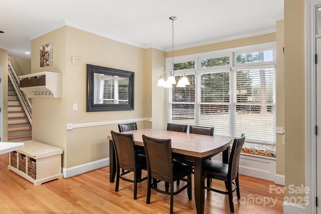 dining room featuring an inviting chandelier, ornamental molding, and light wood-type flooring