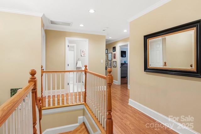 hall with ornamental molding and light hardwood / wood-style flooring