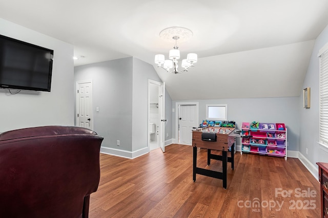 recreation room featuring lofted ceiling, dark wood-type flooring, and a chandelier